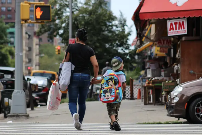 A photo of a mom and son walking in East Harlem